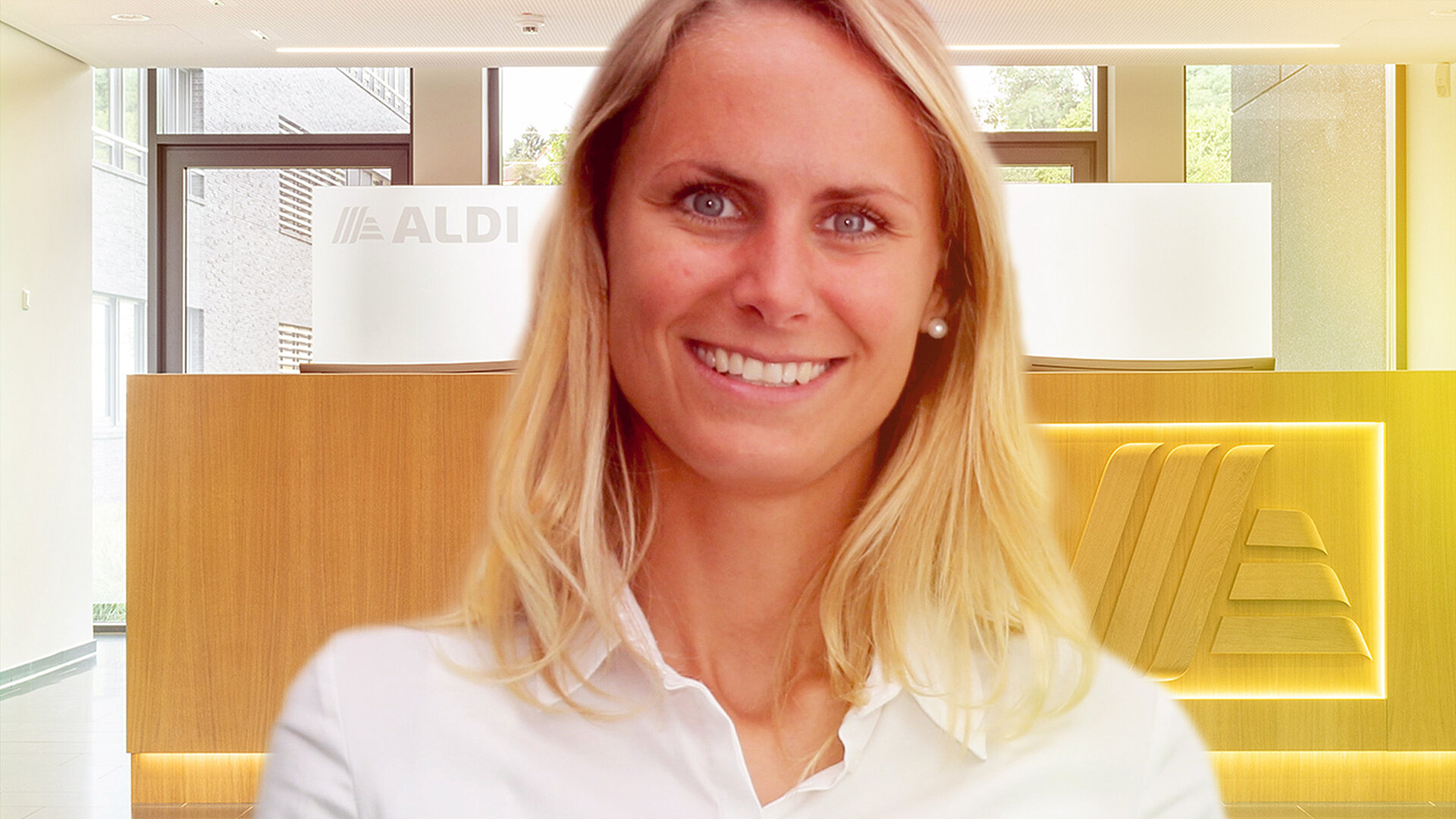 A smiling woman with blonde hair and in a white shirt.