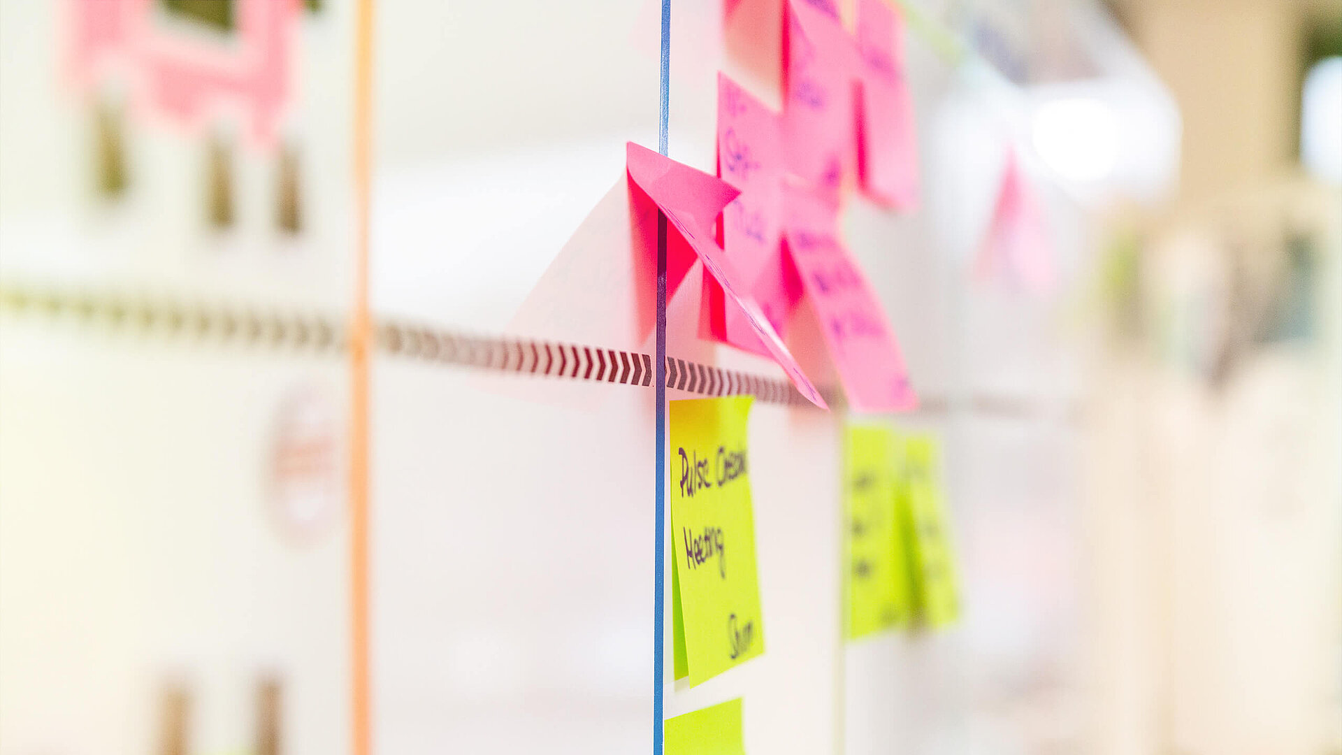 Ein Whiteboard mit Haftnotizen, die verschiedene Informationen enthalten.