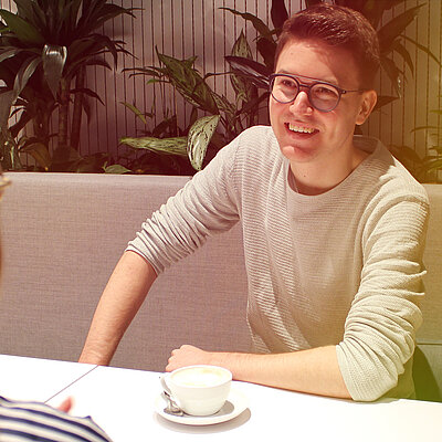 Ein Mann und eine Frau sitzen an einem Tisch mit einer Kaffeetasse.