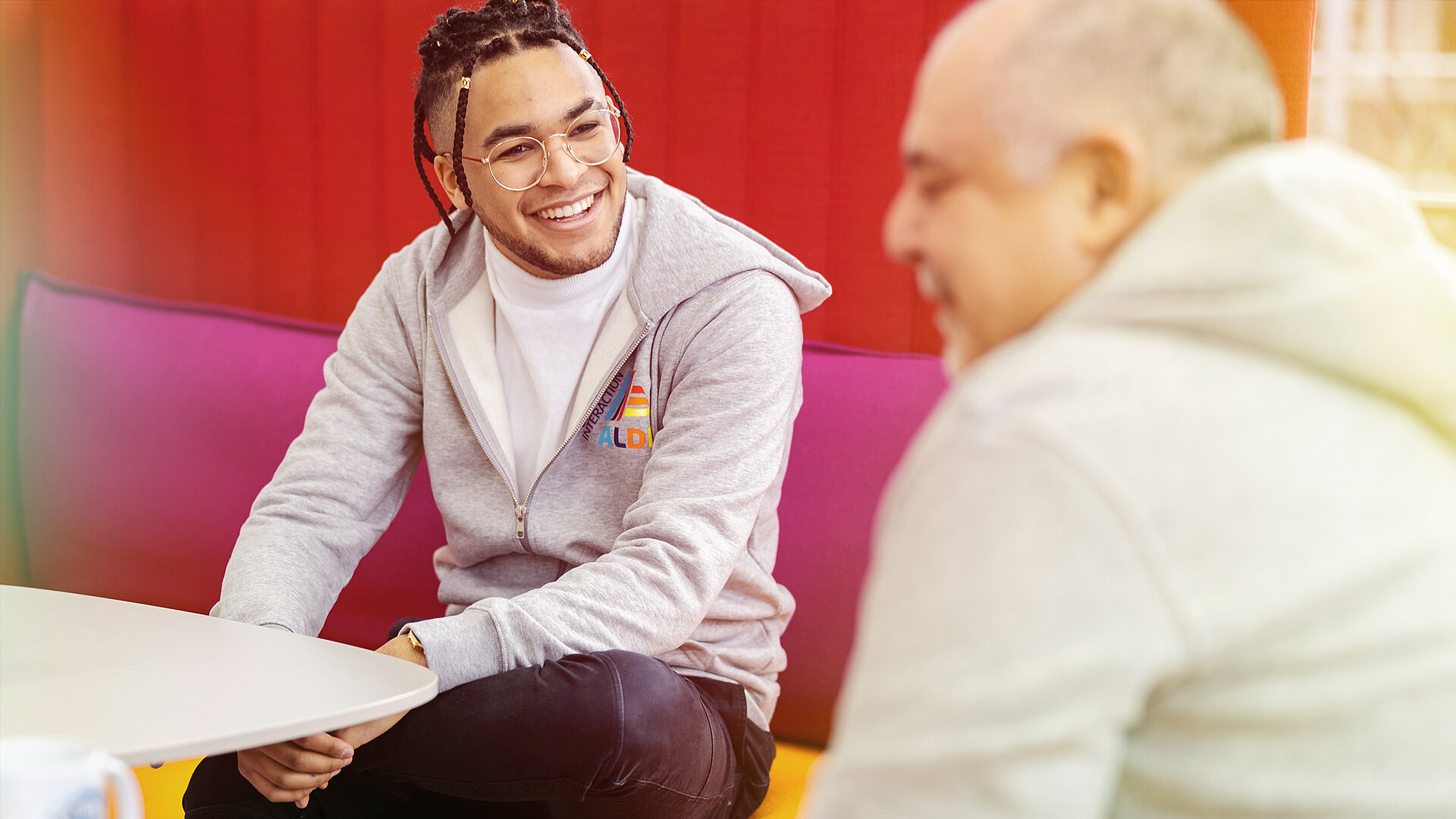 Two men sitting at a table and talking.