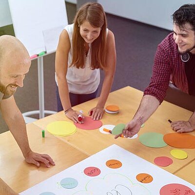 Personen arbeiten zusammen in einem Besprechungsraum.