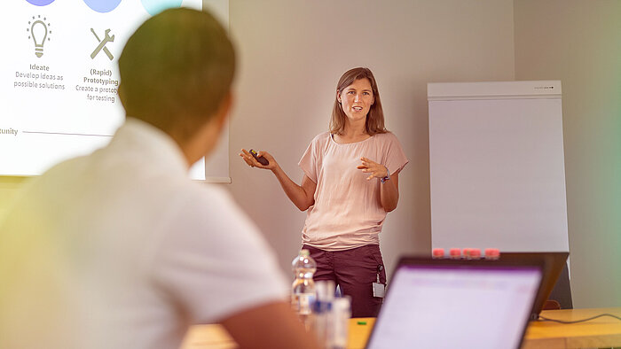 A woman giving a presentation to a group of people.