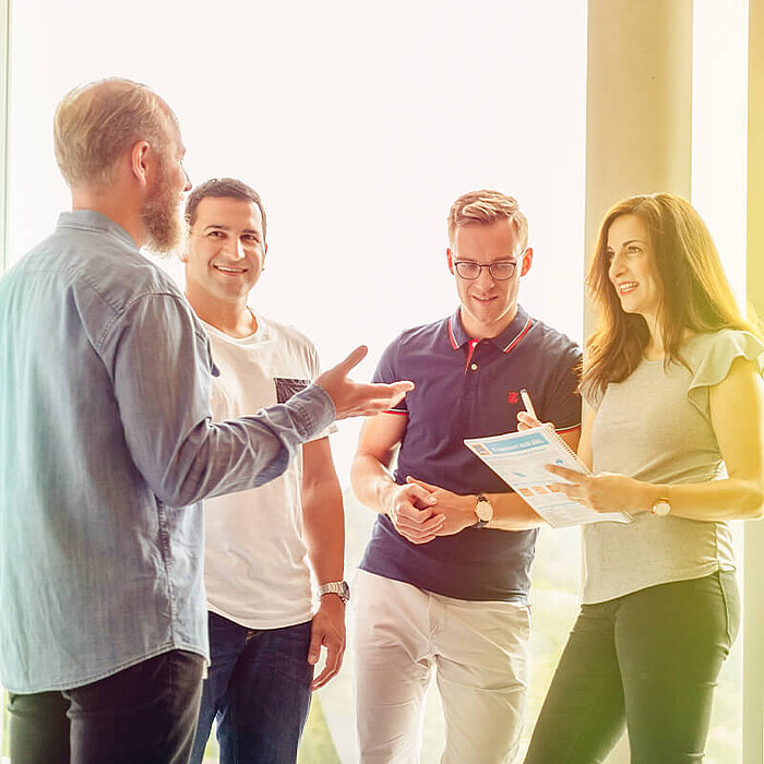 Eine Gruppe von Personen spricht in einem Bürogebäude.